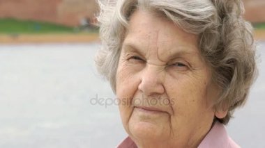 Olgun yaşlı kadın açık havada gülümseyen portresi