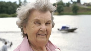 Olgun yaşlı kadın açık havada gülümseyen portresi