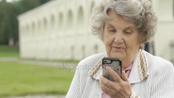 Vieja hablando con un amigo usando un smartphone — Vídeo de stock