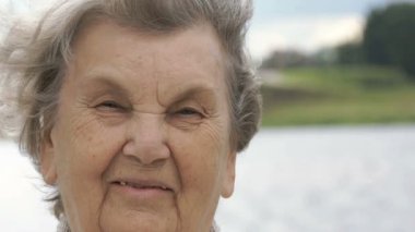 Olgun yaşlı kadın açık havada gülümseyen portresi