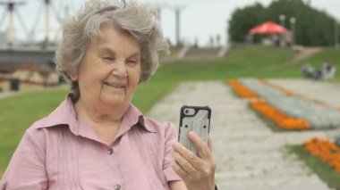 Yaşlı kadın bir cep telefonu kullanarak fotoğraf çeker