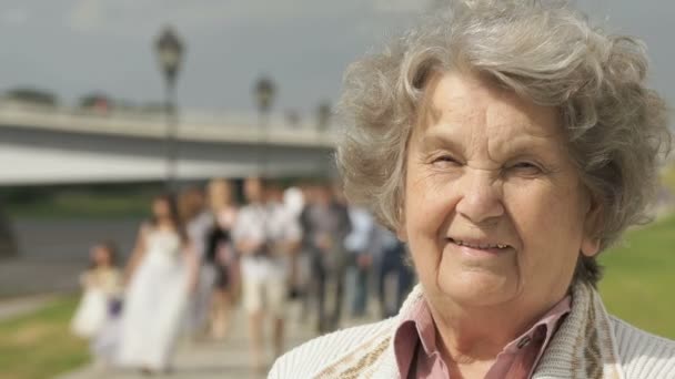 Портрет улыбающейся пожилой женщины на открытом воздухе — стоковое видео