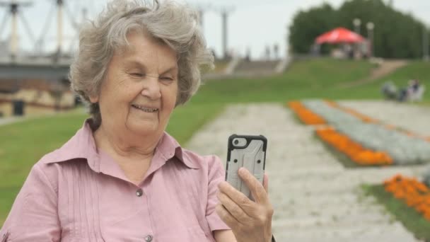 Oudere vrouw neemt foto's met behulp van een mobiele telefoon — Stockvideo