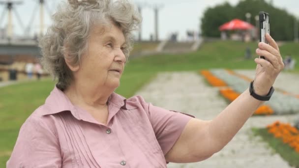 Ηλικιωμένη γυναίκα παίρνει φωτογραφίες χρησιμοποιώντας ένα κινητό τηλέφωνο — Αρχείο Βίντεο