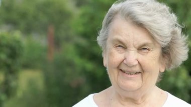 Olgun yaşlı kadın açık havada gülümseyen portresi