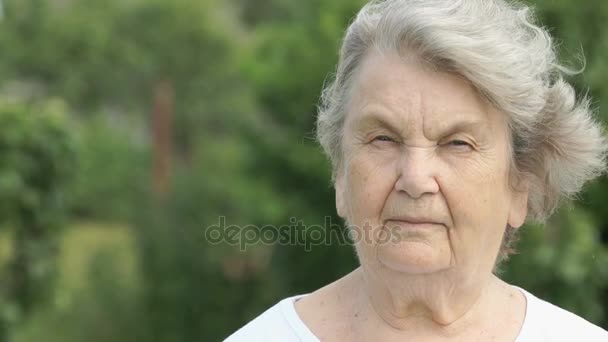 Портрет серйозної зрілої старої жінки на відкритому повітрі — стокове відео