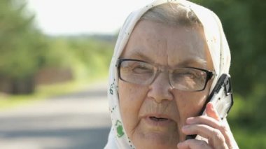 Açık havada Smartphone kullanarak eski kadın görüşmeler gülümseyen