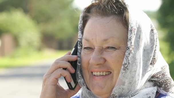 Доросла жінка говорить на срібному мобільному телефоні на відкритому повітрі — стокове відео