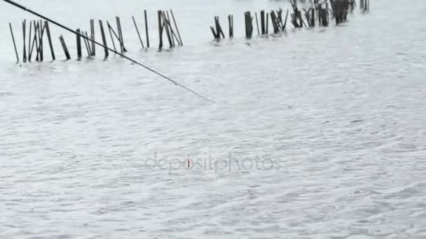 Közeli kép: egy horgászbot és egy piros úszó — Stock videók