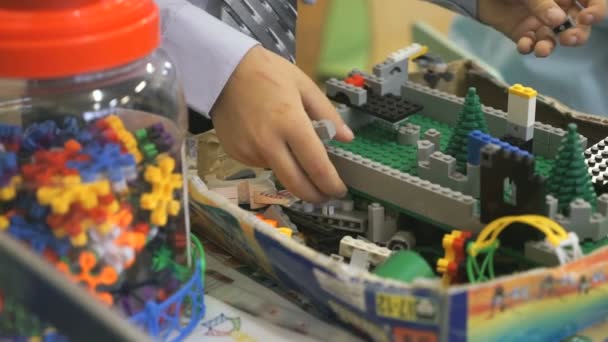 Mãos de um menino desconhecido brincando com o kit de construção — Vídeo de Stock