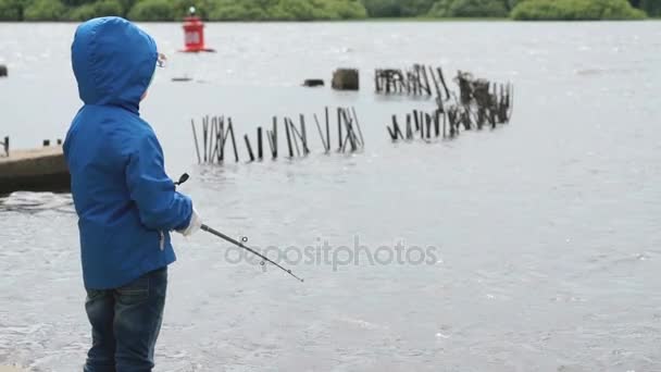 Tenente rapaz está pescando na margem do rio — Vídeo de Stock