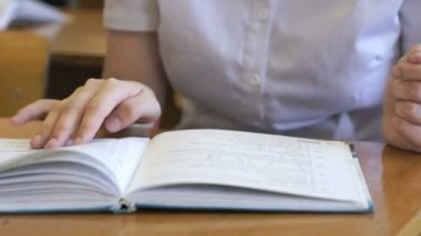 Liseli kızlar okul kitabın sayfalarını çevirir