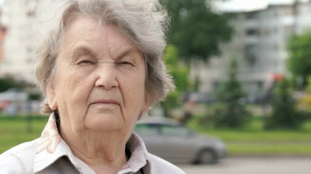 Porträt einer ernsthaften alten Frau im Alter von 80 Jahren im Freien — Stockvideo