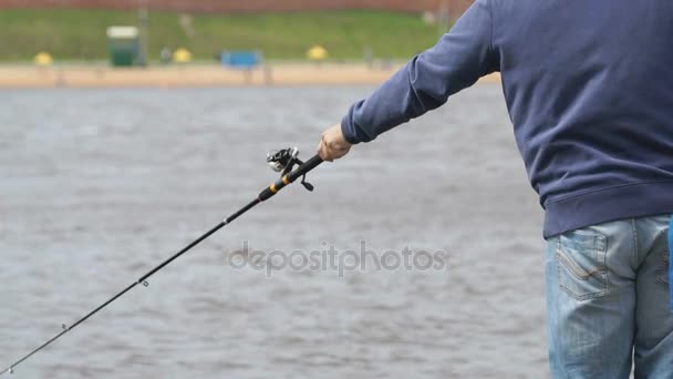 El hombre está pescando en la orilla del río — Vídeo de stock