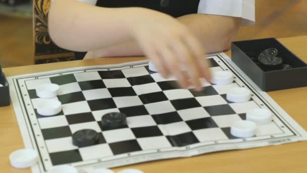 A criança joga damas no jardim de infância dentro de casa — Vídeo de Stock