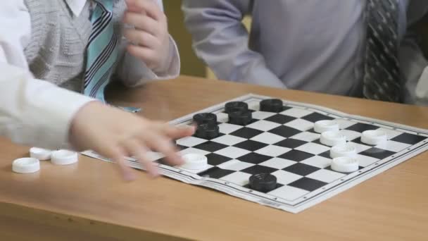 Дети играют в шашки в детском саду в помещении — стоковое видео