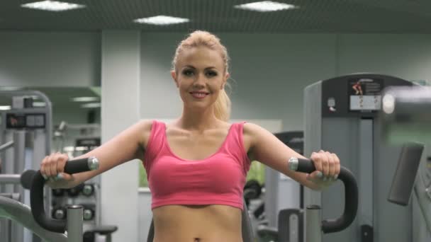 Menina loira bonita envolvida no ginásio dentro de casa — Vídeo de Stock