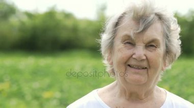 Olgun yaşlı kadın açık havada gülümseyen portresi