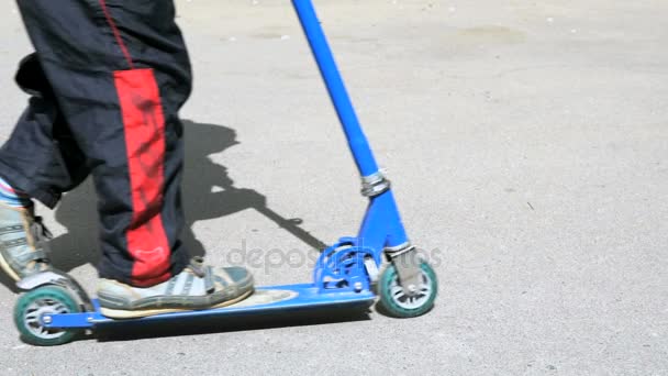 Close-up van voeten van jongen in sneakers op scooter — Stockvideo