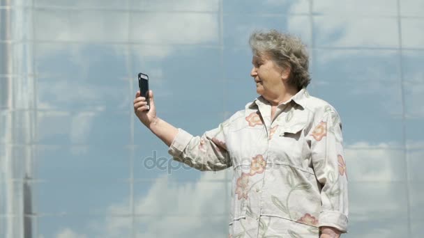 Mulher velha madura tira fotos usando um telefone inteligente — Vídeo de Stock