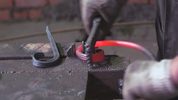 Mains de forgeron faisant une clôture de fer 