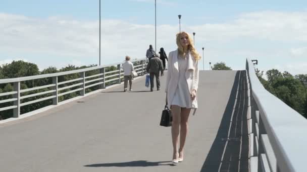 Mujer bastante elegante caminando a lo largo del puente — Vídeos de Stock