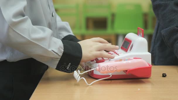 Маленький хлопчик грає з іграшковим телефоном у приміщенні — стокове відео