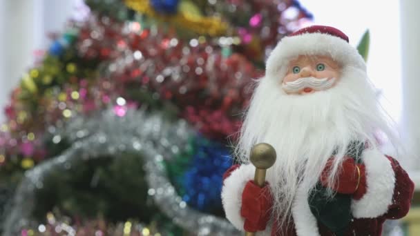 Κοντινό πλάνο παιχνίδι Santa κοντά σε χριστουγεννιάτικο δέντρο — Αρχείο Βίντεο