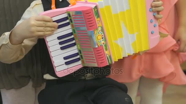 Chłopak gra na akordeonie zabawka — Wideo stockowe