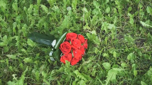 Hochzeitsstrauß aus Rosen liegt im Gras — Stockvideo
