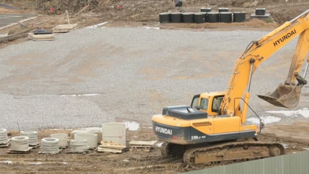 Gelber Bagger im Sommer auf einer Baustelle — Stockvideo