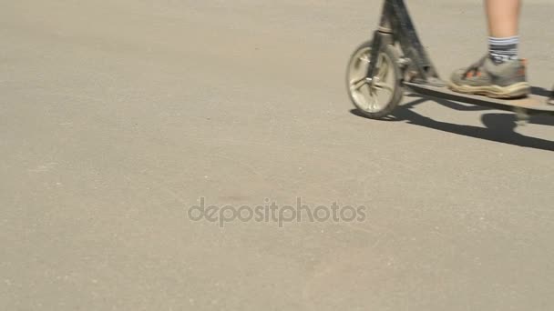 Primer plano de los pies de niño en zapatillas de deporte en scooter — Vídeo de stock