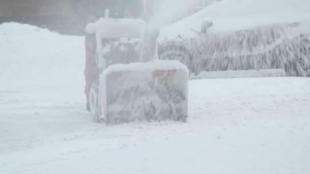 Человек убирает снег снегоуборочной машиной — стоковое видео