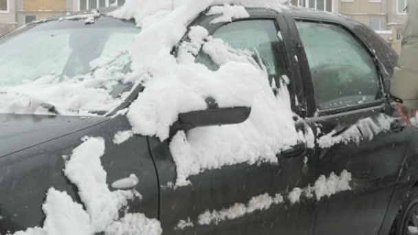 Man schoonmaak auto van sneeuw — Stockvideo