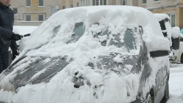 Man schoonmaak auto van sneeuw — Stockvideo
