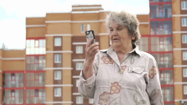 Velha mulher idosa fala usando telefone inteligente ao ar livre — Vídeo de Stock