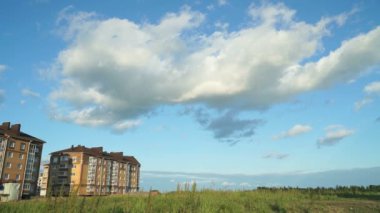 Yeni bina üzerinde kayan yaz bulutlar