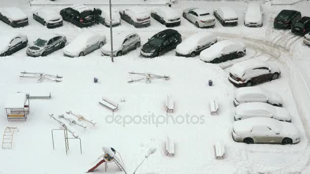 Coches y parque infantil bajo la nieve — Vídeo de stock