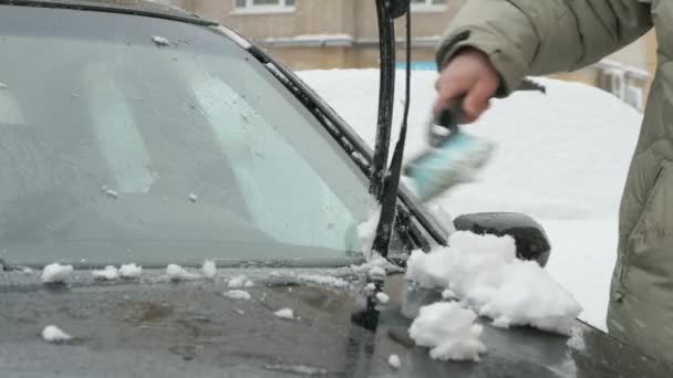Man schoonmaak auto van sneeuw — Stockvideo