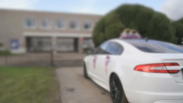 Bröllop bil i bakgrunden av byggnad i city — Stockvideo