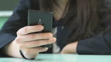 Öğrenci kız smartphone içinde metin yazarak. Yakın çekim