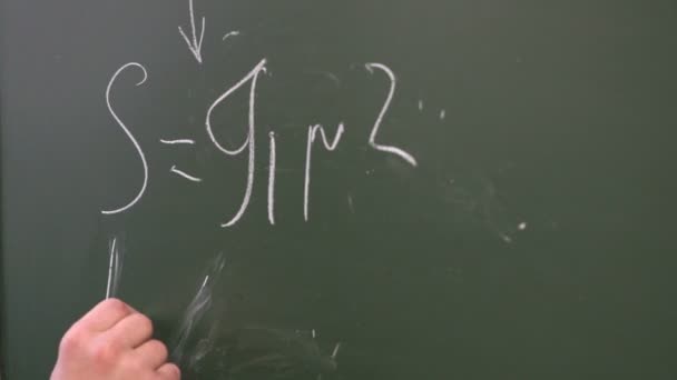 Skolpojke skriva en formel på blackboard — Stockvideo