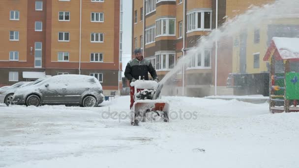 Человек убирает снег снегоуборочной машиной — стоковое видео