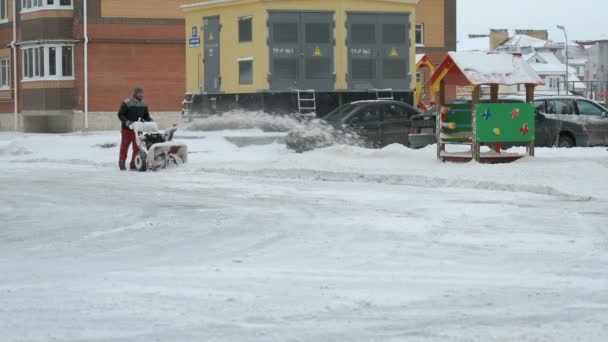 Чоловік знімає сніг з машиною для снігу — стокове відео