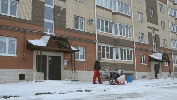Человек убирает снег снегоуборочной машиной — стоковое видео