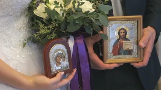 Mariée et marié garder les icônes dans l'Eglise — Video