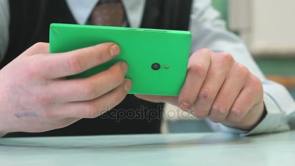 Unbekannter Schüler hält grünes Smartphone in der Hand — Stockvideo