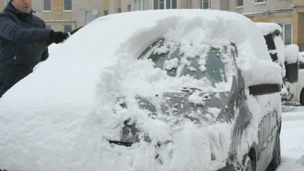 Man rengöring bil från snö — Stockvideo