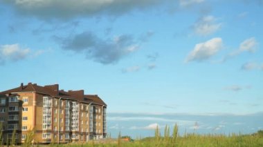 Yeni bina üzerinde kayan yaz bulutlar