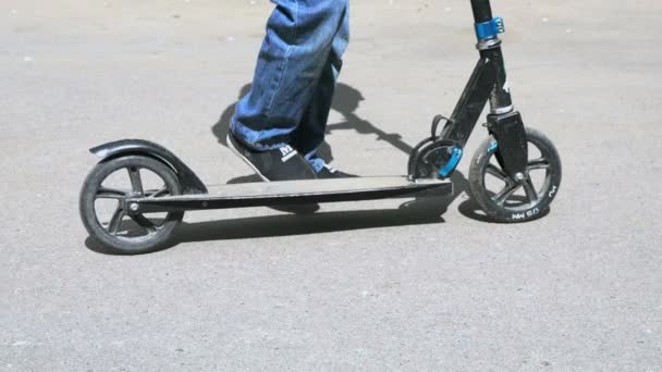 Gros plan des pieds du garçon en baskets sur scooter — Video